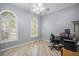 Bright office with wood floors, arched windows, and modern workstation setup at 10709 Rockledge View Dr, Riverview, FL 33579