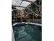 Enjoy this beautiful screened pool at sunset in your backyard with relaxing jacuzzi and elegant blue tile accents at 10709 Rockledge View Dr, Riverview, FL 33579