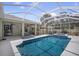 Inviting in-ground pool with a screened enclosure, covered patio, and lush landscaping at 10709 Rockledge View Dr, Riverview, FL 33579