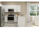 Modern kitchen with stainless steel appliances, white cabinets, and a cozy breakfast nook at 11083 E 65Th Ter, Palmetto, FL 34221