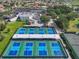 Aerial view of multiple pickleball courts with players, set in a community with parking and buildings at 1110 Jasmine Creek Ct, Sun City Center, FL 33573