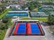 Aerial view of community tennis and pickleball courts surrounded by lush greenery at 1110 Jasmine Creek Ct, Sun City Center, FL 33573