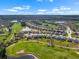 An aerial shot features residences nestled among a golf course's scenic fairways, ponds, and winding cart paths at 1110 Jasmine Creek Ct, Sun City Center, FL 33573