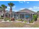 Exterior back of home featuring lanai with patio furniture, landscaping, and palm trees at 1110 Jasmine Creek Ct, Sun City Center, FL 33573