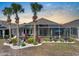 A screened-in pool patio with lush landscaping, palm trees, and an outdoor seating area, perfect for relaxation at 1110 Jasmine Creek Ct, Sun City Center, FL 33573