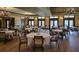 Elegant dining area set with round tables and chairs, lit by ornate chandeliers, ready for special gatherings at 1110 Jasmine Creek Ct, Sun City Center, FL 33573