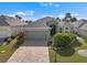 Beautiful single-story home featuring a brick driveway, attached garage, and tropical landscaping at 1110 Jasmine Creek Ct, Sun City Center, FL 33573