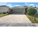 Inviting single-story home with a brick paved driveway and an American flag at 1110 Jasmine Creek Ct, Sun City Center, FL 33573