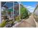 Screened patio with tile flooring and an umbrella, adjoined to a well-landscaped exterior at 1110 Jasmine Creek Ct, Sun City Center, FL 33573
