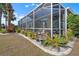 A screened patio with pavers, various plants, and white rock landscaping, perfect for outdoor enjoyment at 1110 Jasmine Creek Ct, Sun City Center, FL 33573