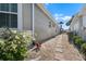 Property side yard and walkway with stone pavers and tropical landscaping at 1110 Jasmine Creek Ct, Sun City Center, FL 33573
