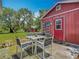 Backyard featuring a patio with a table and chairs next to a red outbuilding at 11912 Mcmullen Loop, Riverview, FL 33569