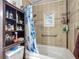 Bright bathroom featuring a tub with tiled wall surround, a small window, and built-in storage shelves at 11912 Mcmullen Loop, Riverview, FL 33569
