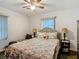 Cozy bedroom with a floral-patterned bed, a ceiling fan, and natural light from the window at 11912 Mcmullen Loop, Riverview, FL 33569