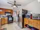 Kitchen with wood cabinets, black oven, and stainless refrigerator at 11912 Mcmullen Loop, Riverview, FL 33569
