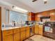 Kitchen featuring a large window, wooden cabinets, and stainless steel dishwasher at 11912 Mcmullen Loop, Riverview, FL 33569