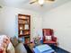 Cozy living room featuring a comfortable couch, bookshelf, red chair, and a center table at 11912 Mcmullen Loop, Riverview, FL 33569