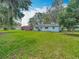 Exterior view of a home with a large yard, a storage shed, and mature trees offering plenty of space for outdoor activities at 11912 Mcmullen Loop, Riverview, FL 33569