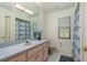 A vintage-style bathroom featuring pink cabinets, tile floors, a long countertop, and a standard tub/shower combo at 120 Fernbrook Rd, Oldsmar, FL 34677