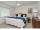 Well-lit bedroom with neutral carpet, an overhead fan, an exterior window, and a vintage wooden dresser at 120 Fernbrook Rd, Oldsmar, FL 34677