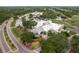 Stunning aerial view of the clubhouse, parking, and putting green surrounded by lush landscaping and mature trees at 120 Fernbrook Rd, Oldsmar, FL 34677