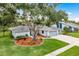 Charming single-story home with a well-manicured lawn, mature tree, and three-car garage at 120 Fernbrook Rd, Oldsmar, FL 34677