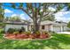 A cozy single-story home featuring mature landscaping, manicured lawn, and an oversized tree in the center of the yard at 120 Fernbrook Rd, Oldsmar, FL 34677