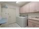 An interior laundry room with pink cabinets, a utility sink, and washer and dryer hookups at 120 Fernbrook Rd, Oldsmar, FL 34677
