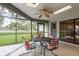 The screened-in patio features a ceiling fan, table, and chairs, ideal for outdoor dining and relaxing at 120 Fernbrook Rd, Oldsmar, FL 34677