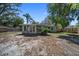 Backyard view of a charming blue home with mature trees and foliage at 12304 Woodleigh Ave, Tampa, FL 33612
