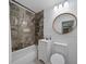 Updated bathroom with a marble-look shower, modern vanity and new fixtures at 12304 Woodleigh Ave, Tampa, FL 33612