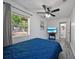 Bedroom with a blue bed, wood-look floors and a view of the backyard at 12304 Woodleigh Ave, Tampa, FL 33612