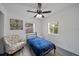 Bright bedroom with neutral walls, wood-look floors, and a stylish accent chair at 12304 Woodleigh Ave, Tampa, FL 33612