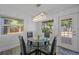 Cozy dining area with a glass table, four chairs, and a modern chandelier at 12304 Woodleigh Ave, Tampa, FL 33612