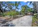 Quaint single-story house with a well manicured lawn, white picket fence, and spacious driveway at 12304 Woodleigh Ave, Tampa, FL 33612