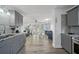 Open kitchen showcasing gray cabinetry, granite countertops, and an adjacent dining area at 12304 Woodleigh Ave, Tampa, FL 33612