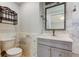 Bathroom featuring white marble tiled walls, single sink vanity, and toilet at 1242 Bermuda St, Clearwater, FL 33755