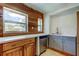 This partially renovated kitchen has stainless steel appliances and wood-paneled walls at 1242 Bermuda St, Clearwater, FL 33755