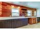 The partially renovated kitchen features wood-paneled walls, floating shelves, and two-tone cabinetry at 1242 Bermuda St, Clearwater, FL 33755