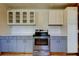 A partially renovated kitchen with gray lower cabinets and stainless steel appliances at 1242 Bermuda St, Clearwater, FL 33755