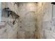 Shower featuring white marble tiled walls, a showerhead, and a soap shelf at 1242 Bermuda St, Clearwater, FL 33755