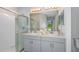 Bright bathroom featuring double sinks, sleek cabinetry, and a glass-enclosed shower at 12435 Gust Ct, Hudson, FL 34669