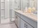 Beautiful bathroom featuring a double vanity, gray cabinets, and a glass-enclosed shower at 12435 Gust Ct, Hudson, FL 34669