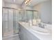 Modern bathroom with double sinks, ample countertop space, and a glass-enclosed shower at 12435 Gust Ct, Hudson, FL 34669