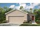 Charming single-Gathering home with a two-car garage, well-manicured lawn, and beautiful front door at 12435 Gust Ct, Hudson, FL 34669