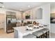 Modern kitchen with stainless steel appliances, gray cabinetry, quartz countertops, and breakfast bar seating at 12435 Gust Ct, Hudson, FL 34669