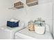 Neat laundry area with storage shelves, a front-load washer and dryer, and decorative canisters at 12435 Gust Ct, Hudson, FL 34669