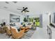 Bright living area with white sofa, wicker chairs, rug, ceiling fan and glass sliding doors at 12435 Gust Ct, Hudson, FL 34669