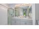 Bathroom with double sinks, white countertops, vanity with cabinets and glass shower at 12469 Gust Ct, Hudson, FL 34669
