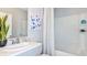 White bathroom with framed mirror, a shower/tub combo, and neutral finishes at 12469 Gust Ct, Hudson, FL 34669